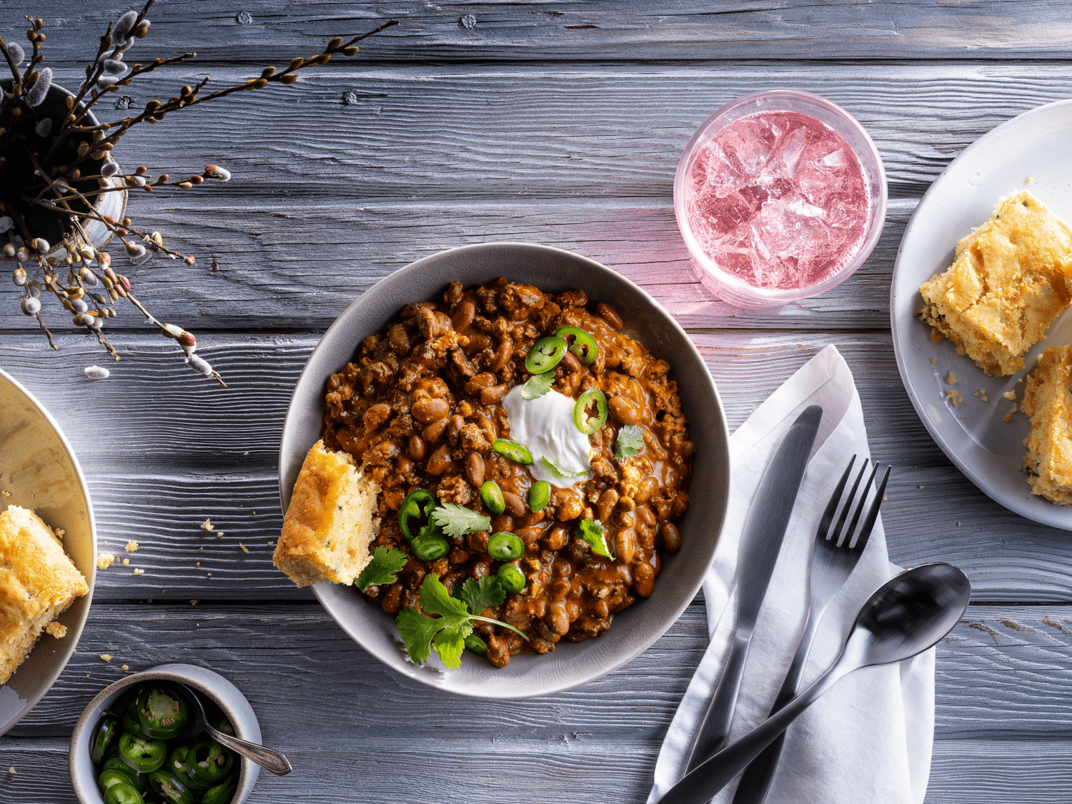 Vista cenital de un plato de fríjoles y Chili con carne CHEF MATE® servido junto a una bebida fría