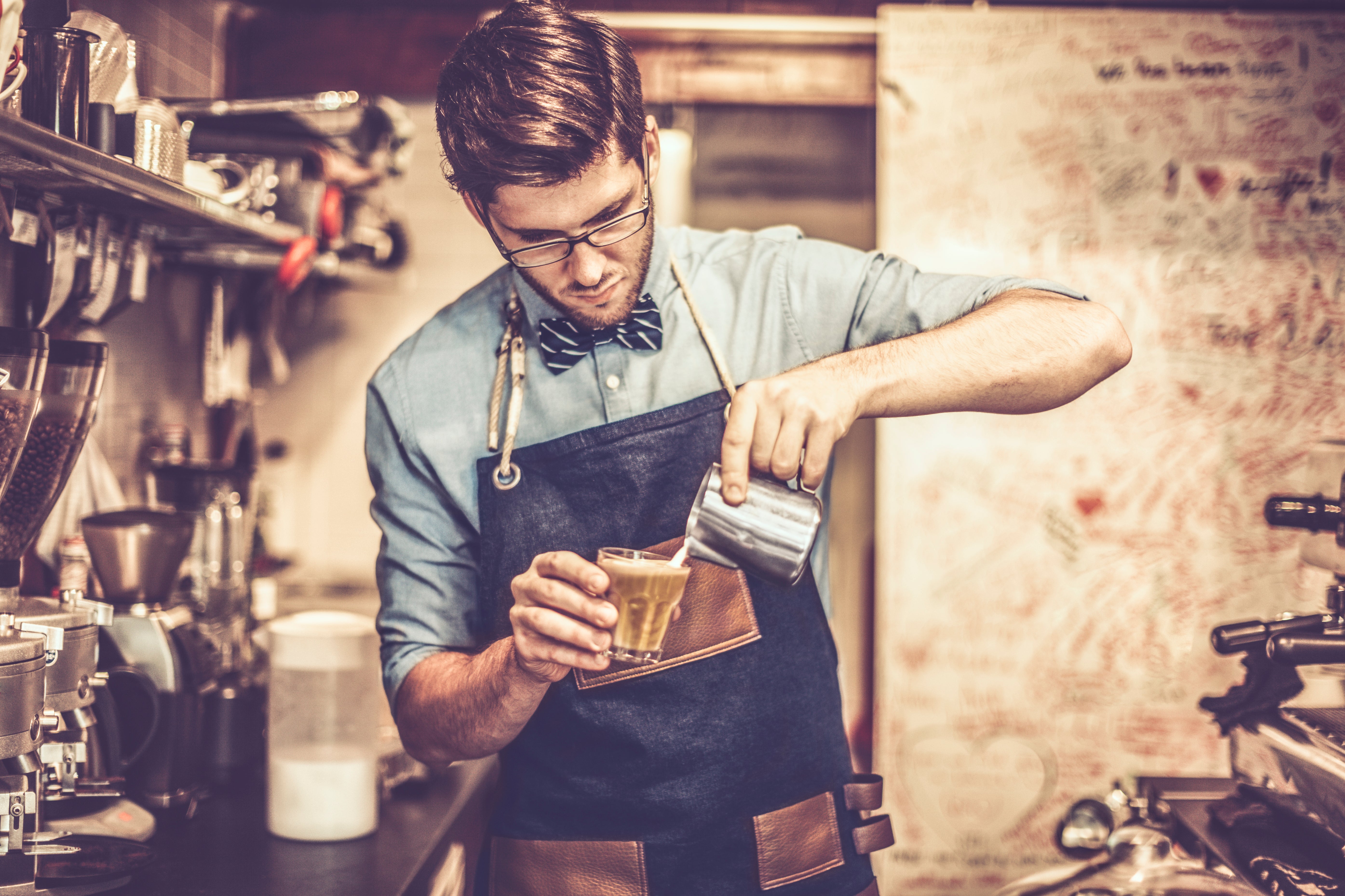 Joven barista preparando un café