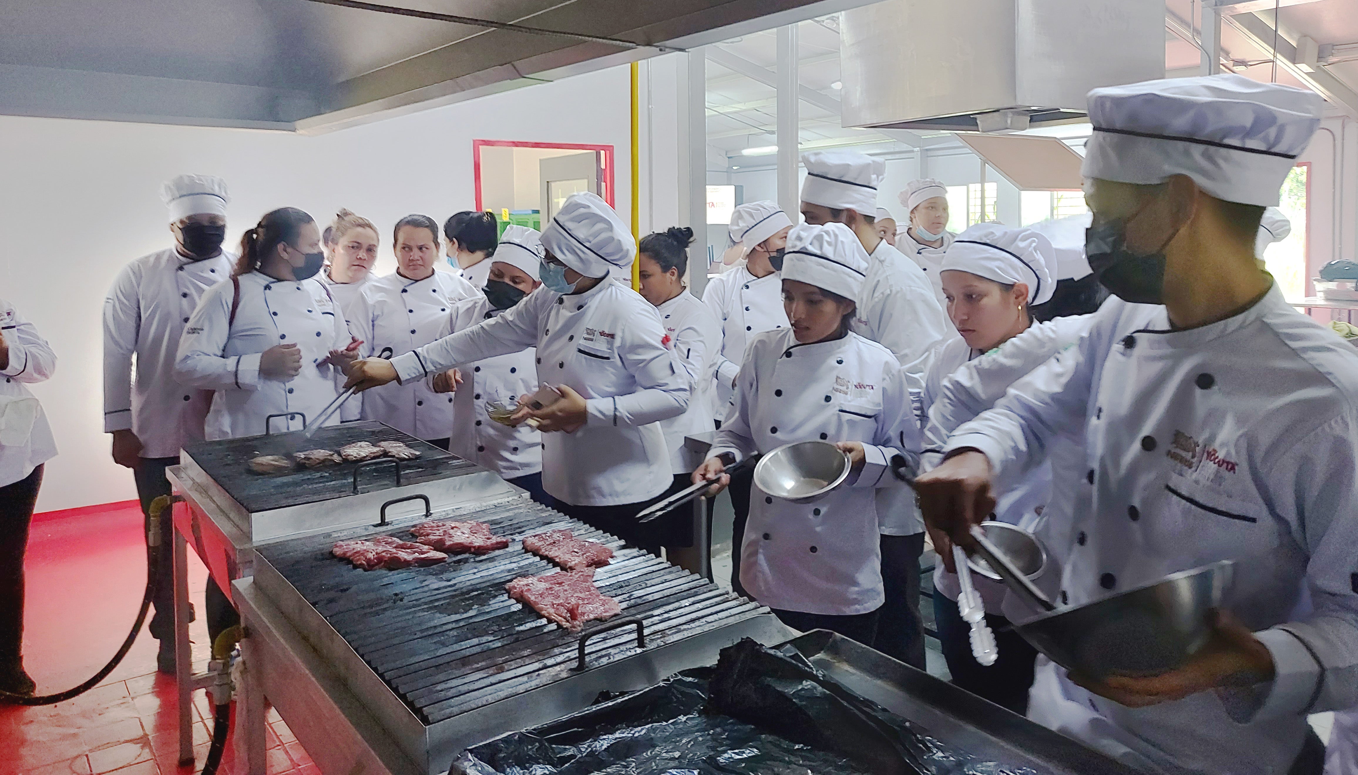 Jóvenes YOCUTA preparando una demostración de carne a la parrila