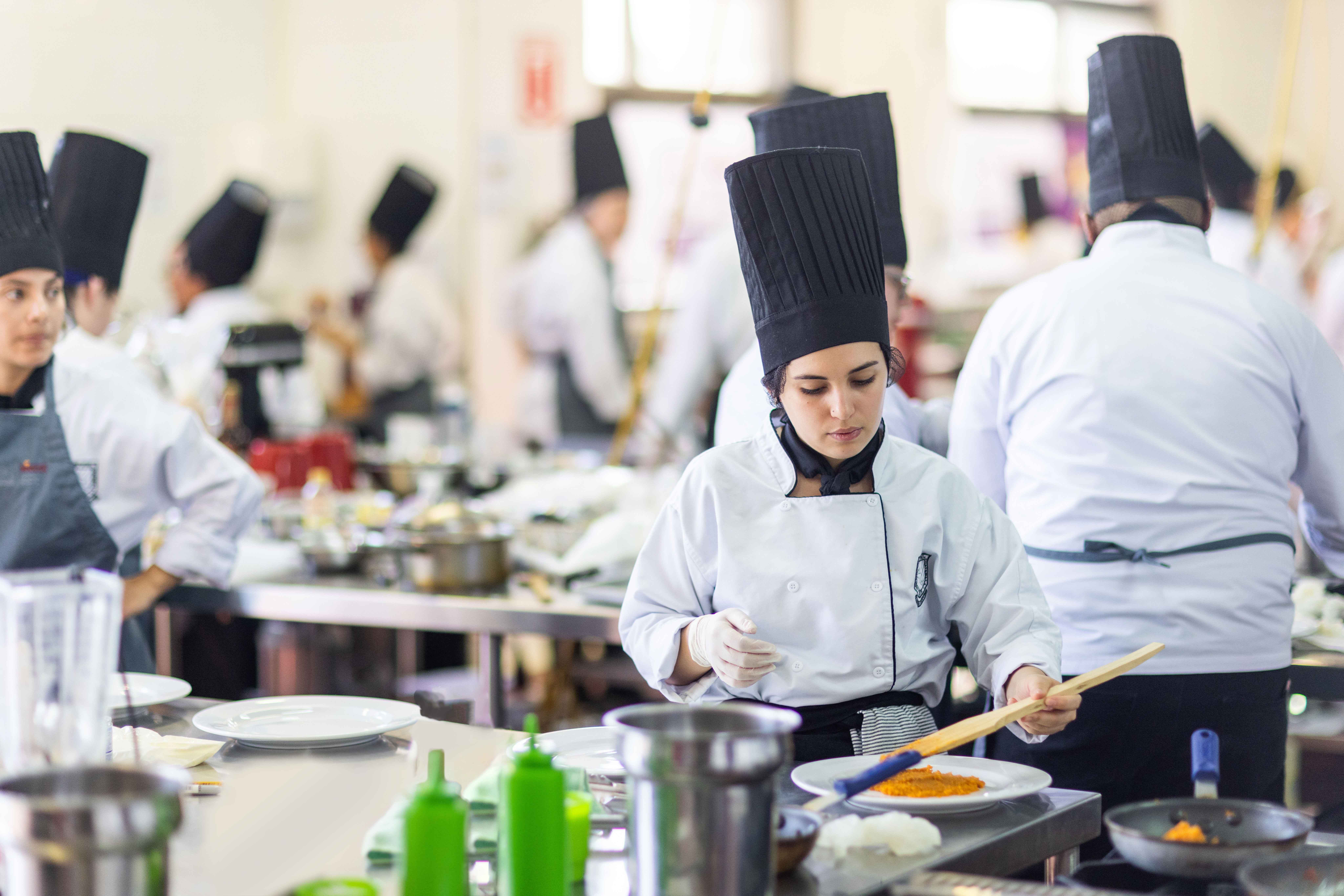 Una cocina profesional con varios jóvenes chef preparando platos con productos MAGGI®