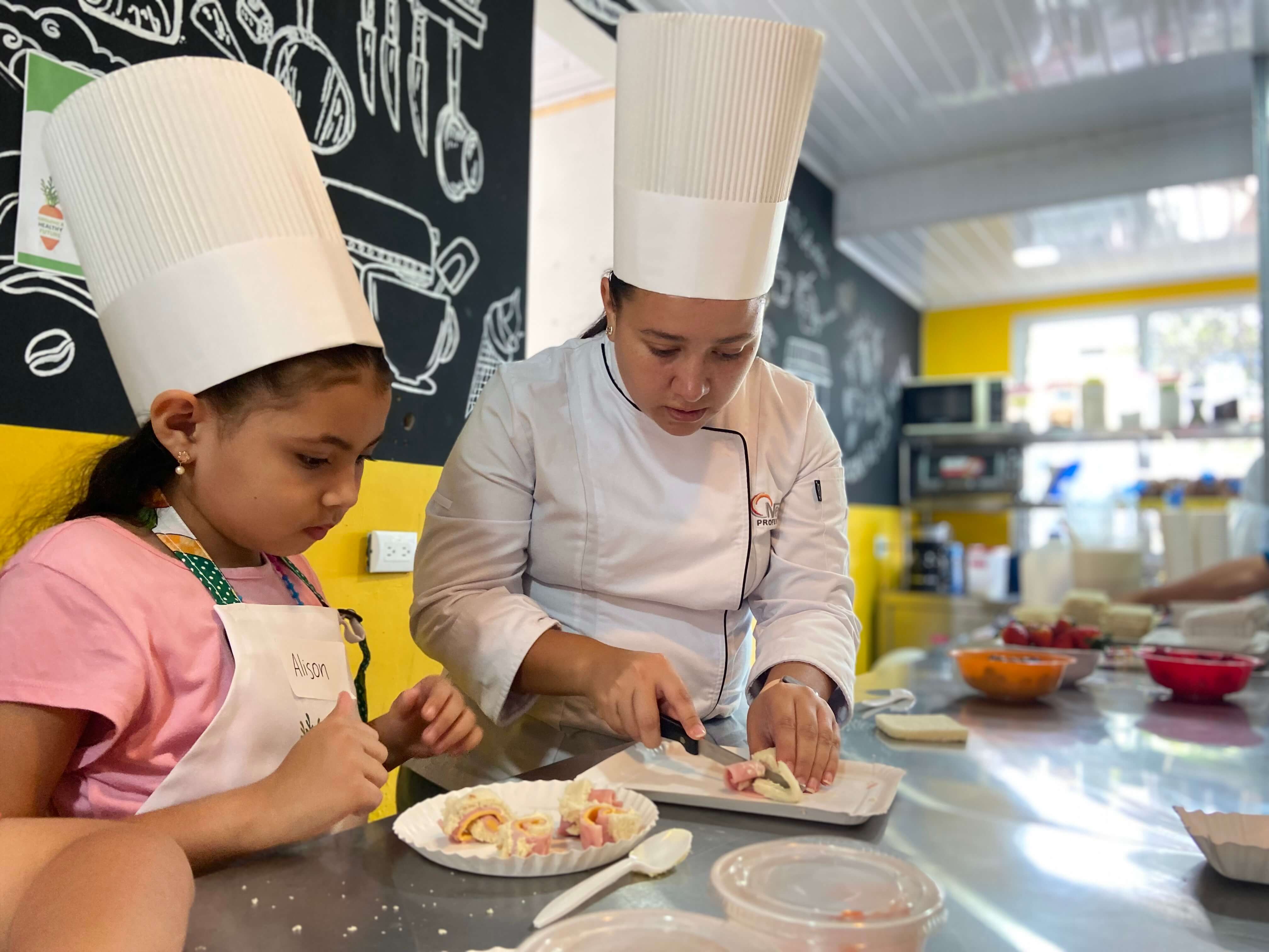 Chef sirviendo receta preparada junto con una niña