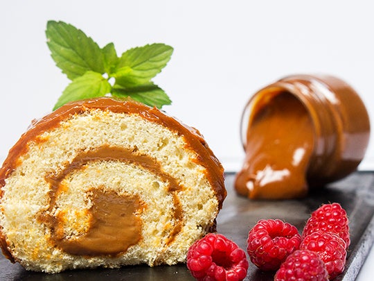Una rebanada de pastel enrollado con relleno de caramelo. Postres elaborados con un proveedor de lácteos al por mayor.