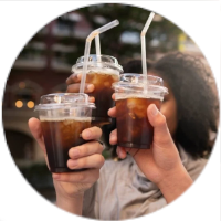 Tres personas brindando con vasos de café helado