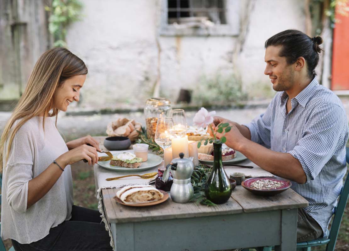 Pareja de Millennials disfruta de una experiencia gastronómica al aire libre en un restaurante con ambiente único