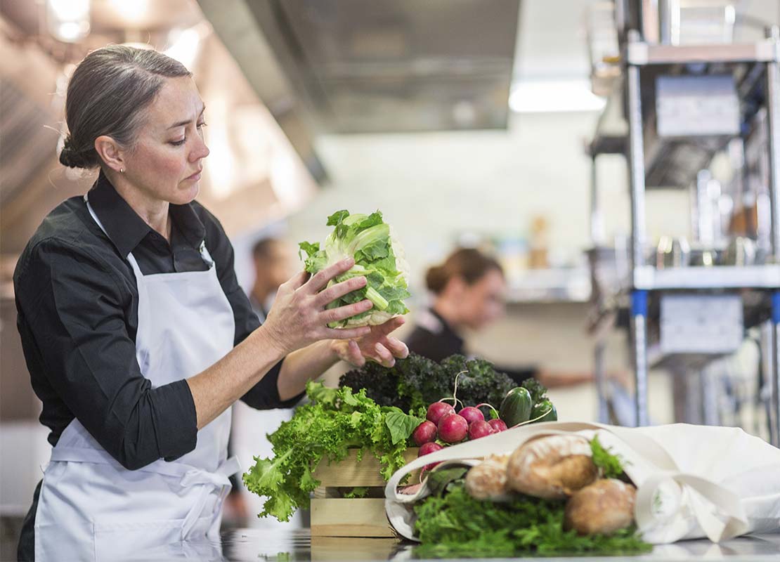 Chef verificando la calidad de frutas y verduras que llegan a su restaurante