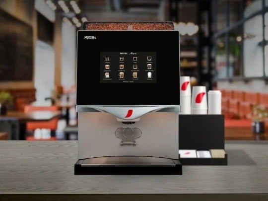 máquina de café profesional NESCAFÉ con vasos Nescafé y insumos de café