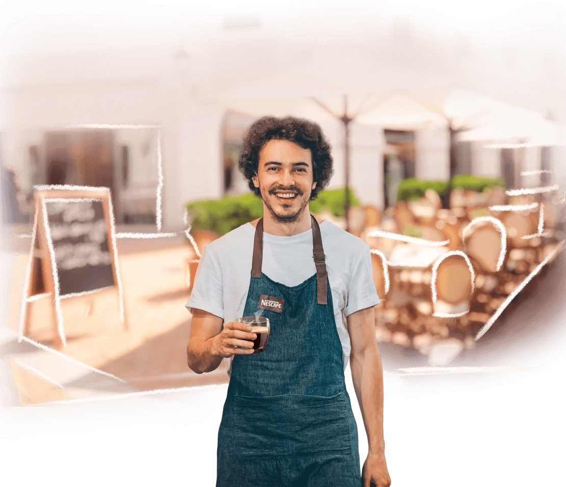 Fuera de una cafetería, barista sostiene un vaso de café NESCAFÉ®