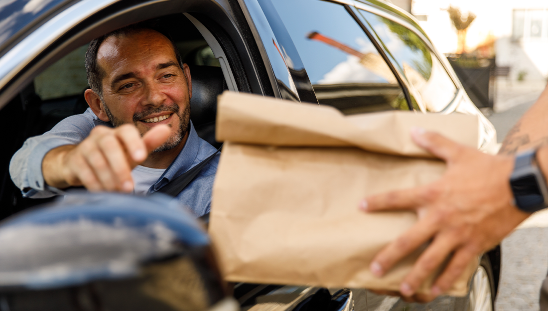 Cliente en su carro recibiendo su pedido gracias a la IA para restaurantes