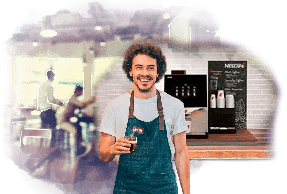 Barista sostiene un vaso de café y tras él, una Máquina NESCAFÉ® de grano sobre la barra de una cafetería