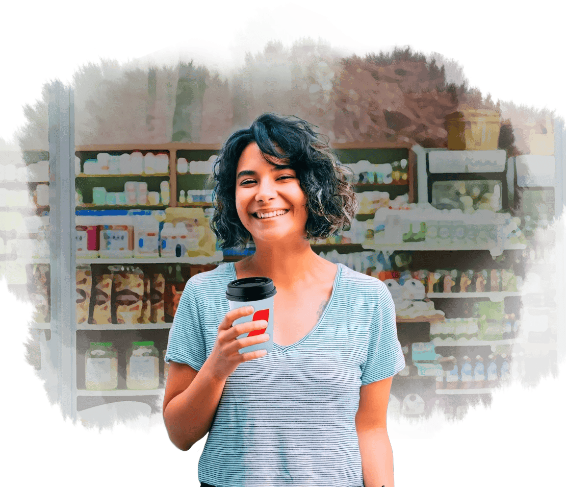 A las afueras de una cafetería, mujer sostiene un vaso de NESCAFÉ®