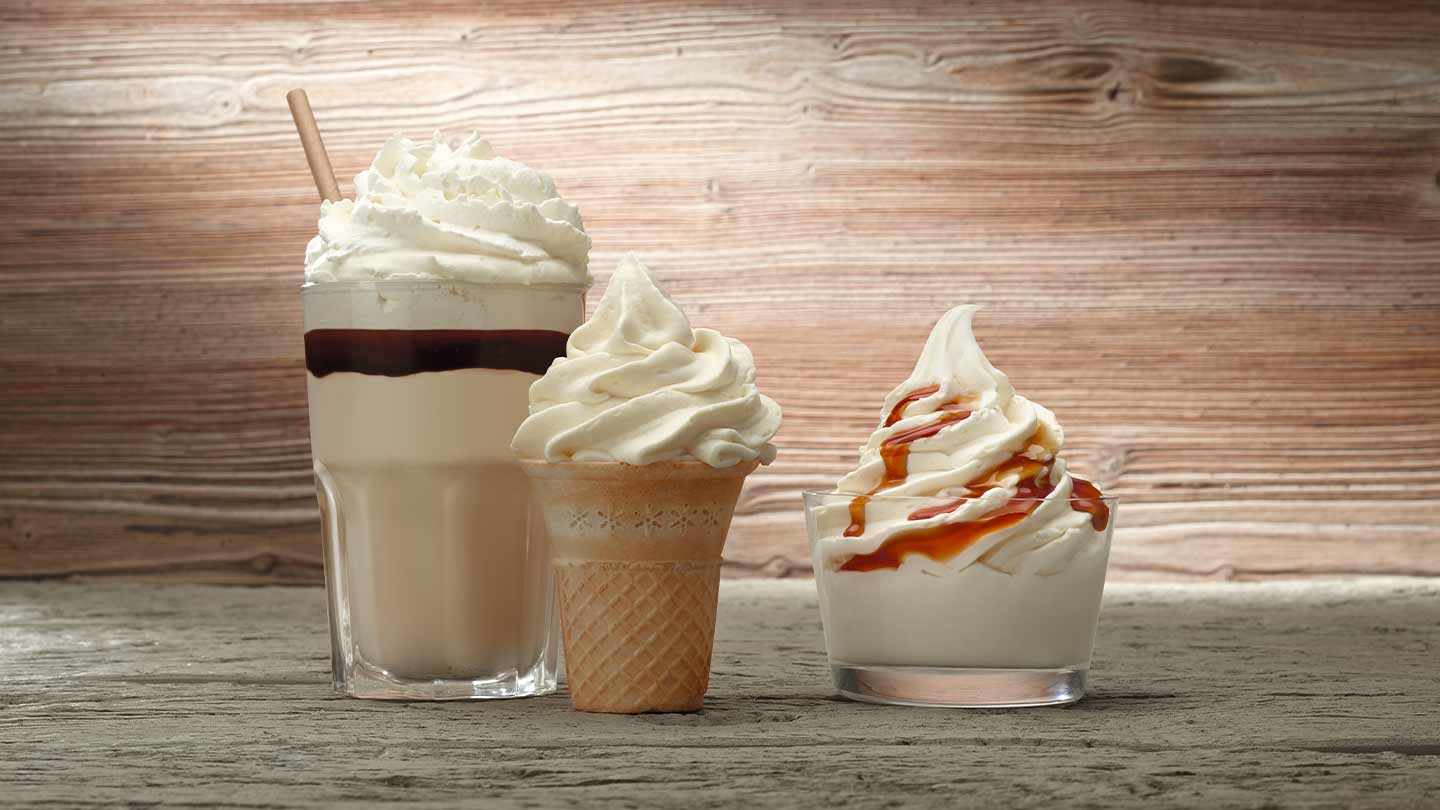 Batido con nata montada, helado en cono y en vaso con caramelo elaborados con productos lácteos