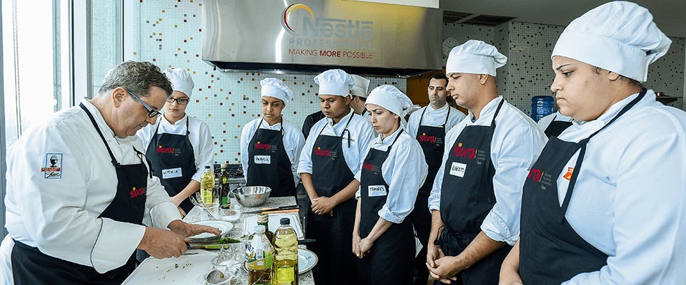 Estudiantes del Programa YOCUTA observan el trabajo de un chef de NESTLÉ PROFESSIONAL® guiando una clase