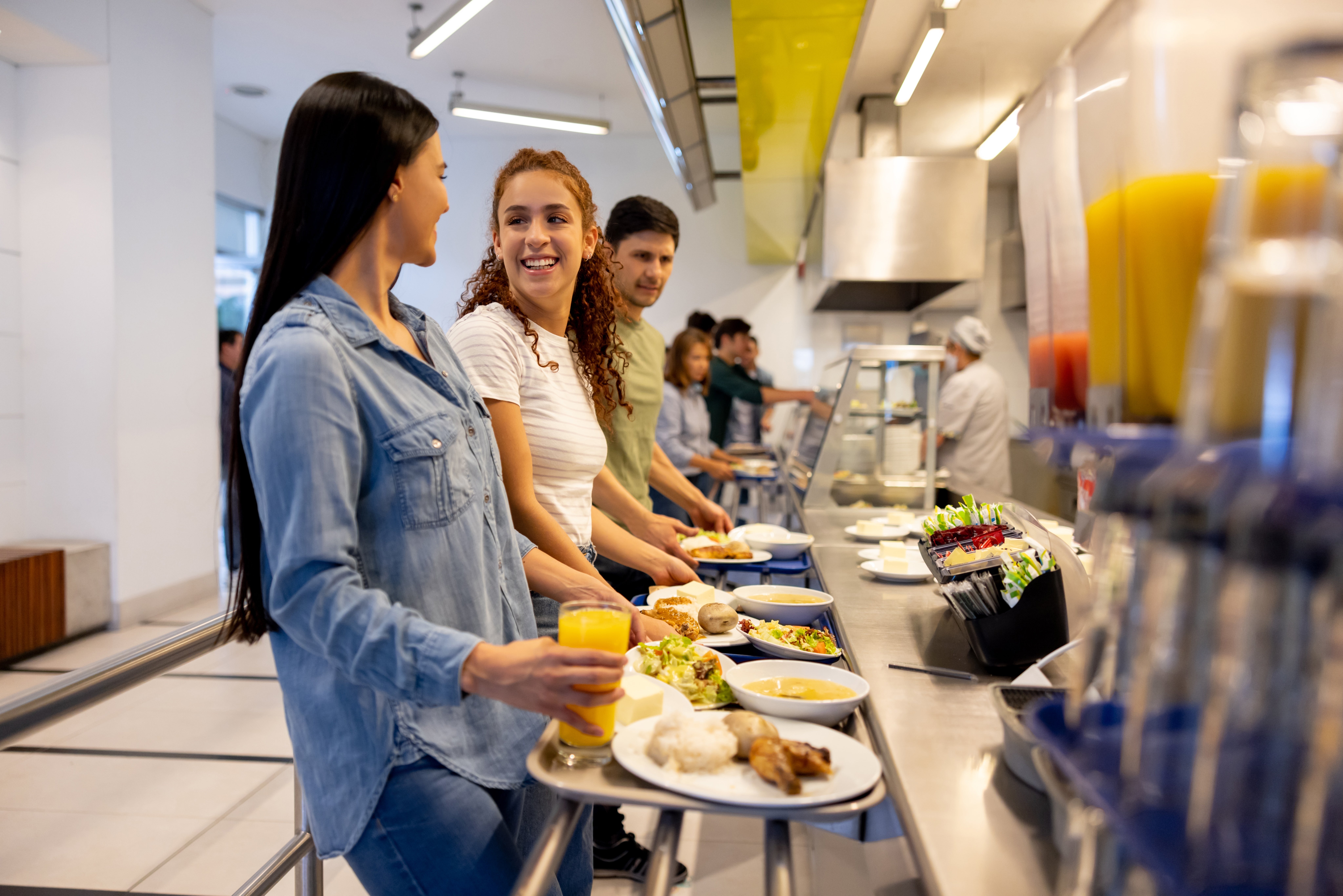 Dos jóvenes universitarias sirven su almuerzo en un servicio de buffet