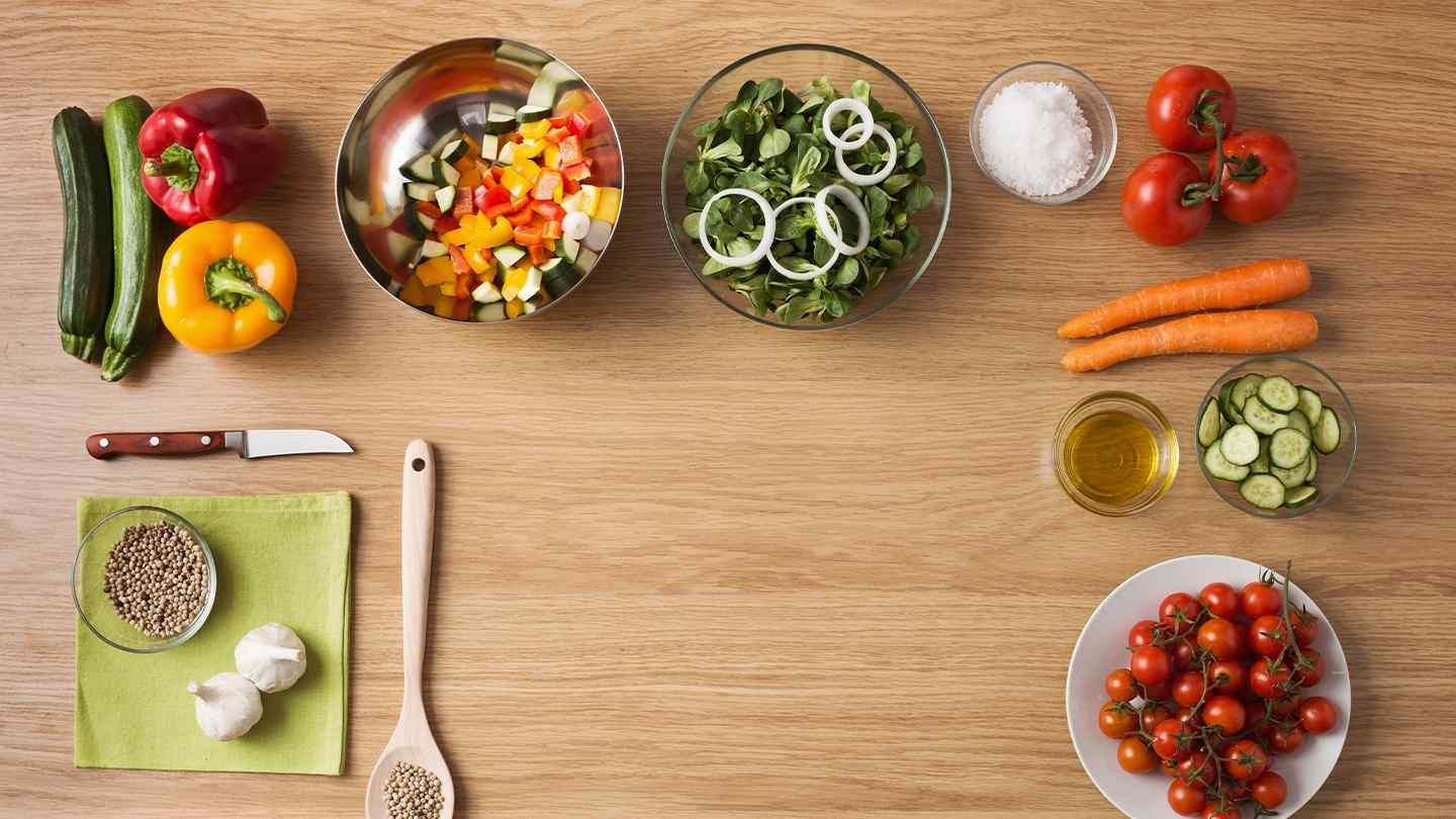 Mesa con ingredientes frescos y coloridos dispuestos ordenadamente para preparar un plato