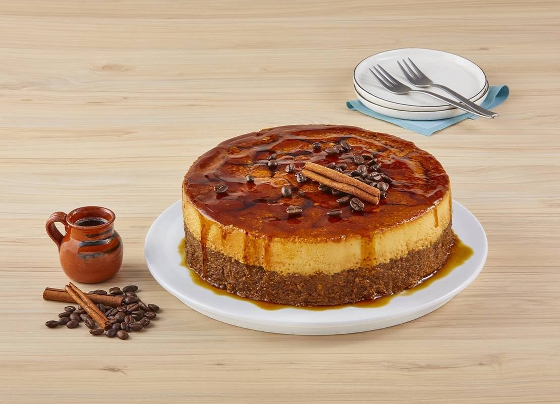 Pastel de olla servicio en un plato, decorado con café y astillas de canela, al lado jarra con café