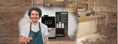 Barista sonriente frente a cafeteras industriales NESCAFÉ® e insumos.