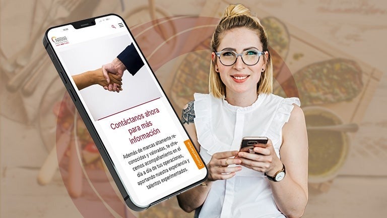 Mujer sonriente con su celular en la mano contactando en NESTLÉ PROFESSIONAL®.