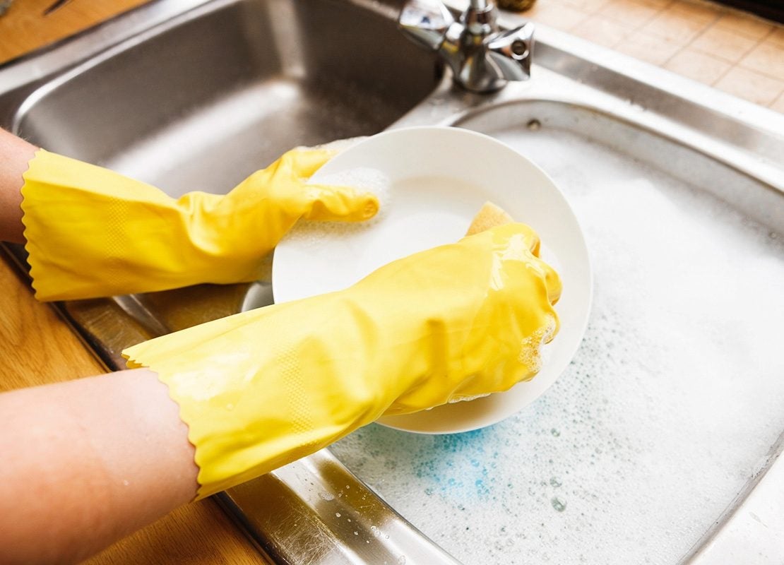 Lavado de platos con guantes como parte de las buenas prácticas de higiene en cocinas profesionales