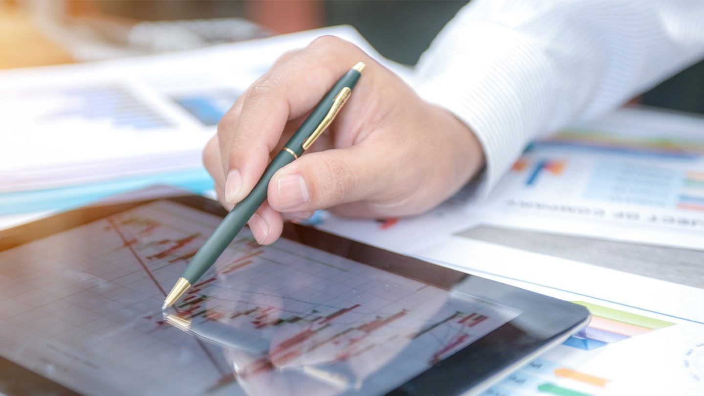 Persona analizando gráficos en una Tablet para aplicar una estrategia de precios en un negocio gastronómico.