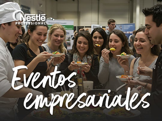 Grupo de personas degustando alimentos en un evento empresarial dirigido por un chef