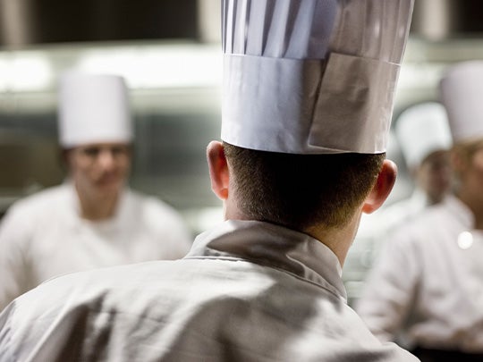 Chef de cocina liderando al equipo durante el servicio en una cocina profesional