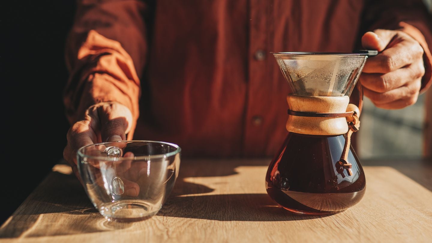 Barista prepara café filtrado con método manual tipo Chemex para una extracción limpia y aromática.
