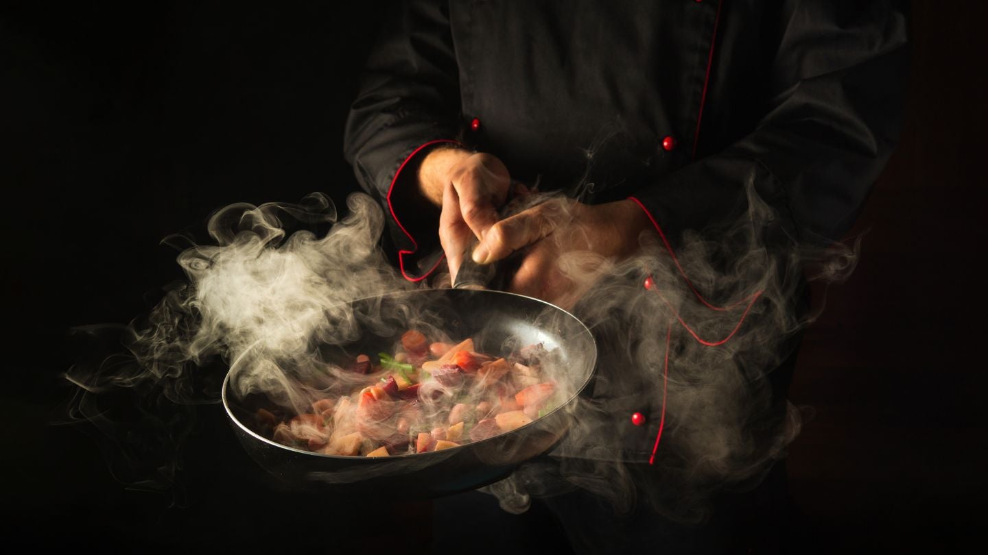Chef sirviendo un plato gourmet en una cocina profesional, utilizando food solutions
