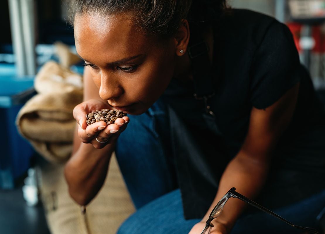 Barista evalúa granos para identificar aromas y sabores de café en proceso de cata.