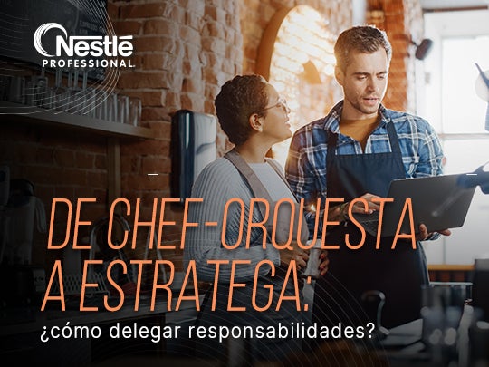 Dos personas conversan mientras revisan una tablet en una cocina profesional