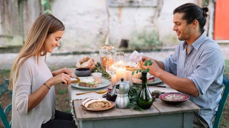 Pareja disfrutando de una cena romántica en un restaurante al aire libre