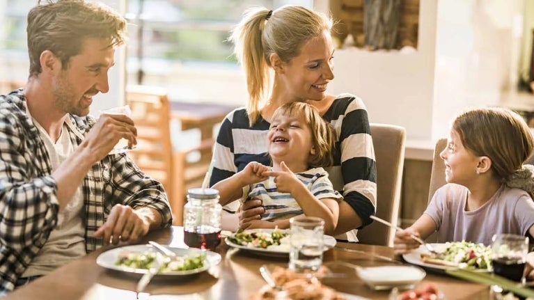 Familia de 4 miembros disfruta de un brunch mientras celebran el día de la madre en un restaurante