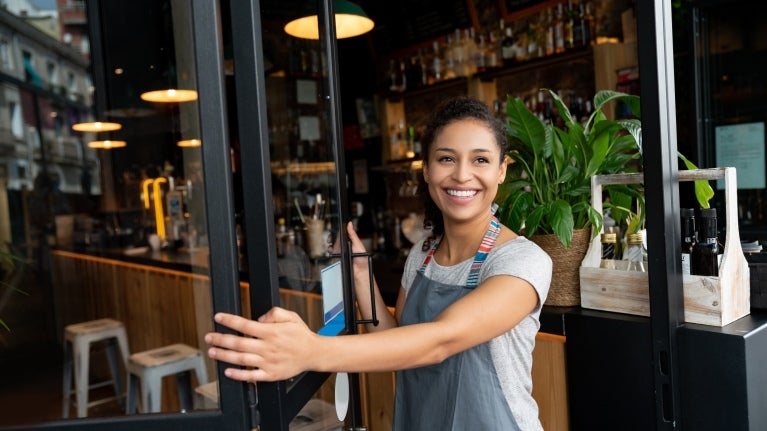 Dueña abriendo la puerta de su cafetería