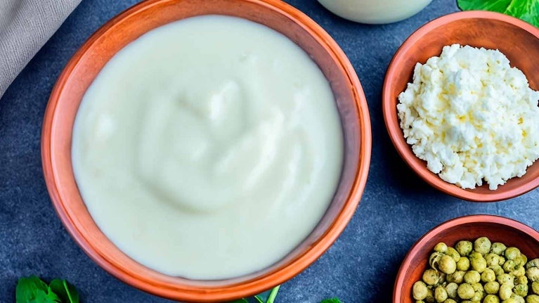Cuencos con guisantes secos, yogur, requesón y una botella de bebida vegetal como sustitutos de la leche