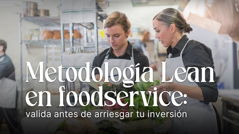 Dos personas revisan procesos en una cocina profesional, ilustrando la aplicación de metodología lean.