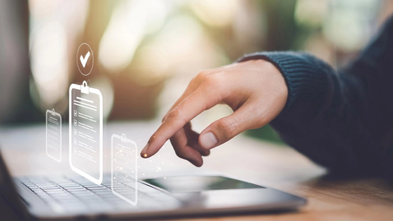 Mano revisa checklist digital en laptop como parte del control de calidad de alimentos. 