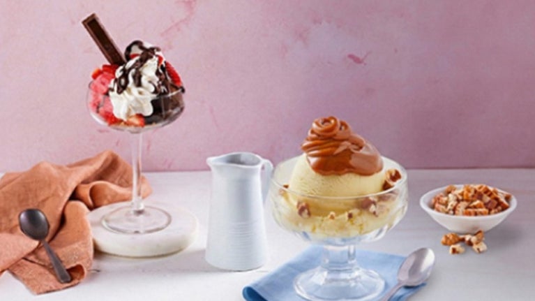 Vasos de helado con frutas, crema, chocolate y caramelo como opciones de toppings para helados 