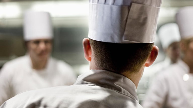 Chef de cocina liderando al equipo durante el servicio en una cocina profesional