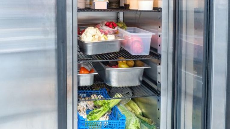 Refrigerador con alimentos organizados para conservar propiedades organolépticas en cocina profesional.