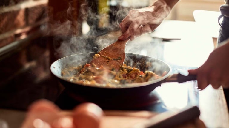 Chef sirviendo un plato gourmet en una cocina profesional, utilizando food solutions