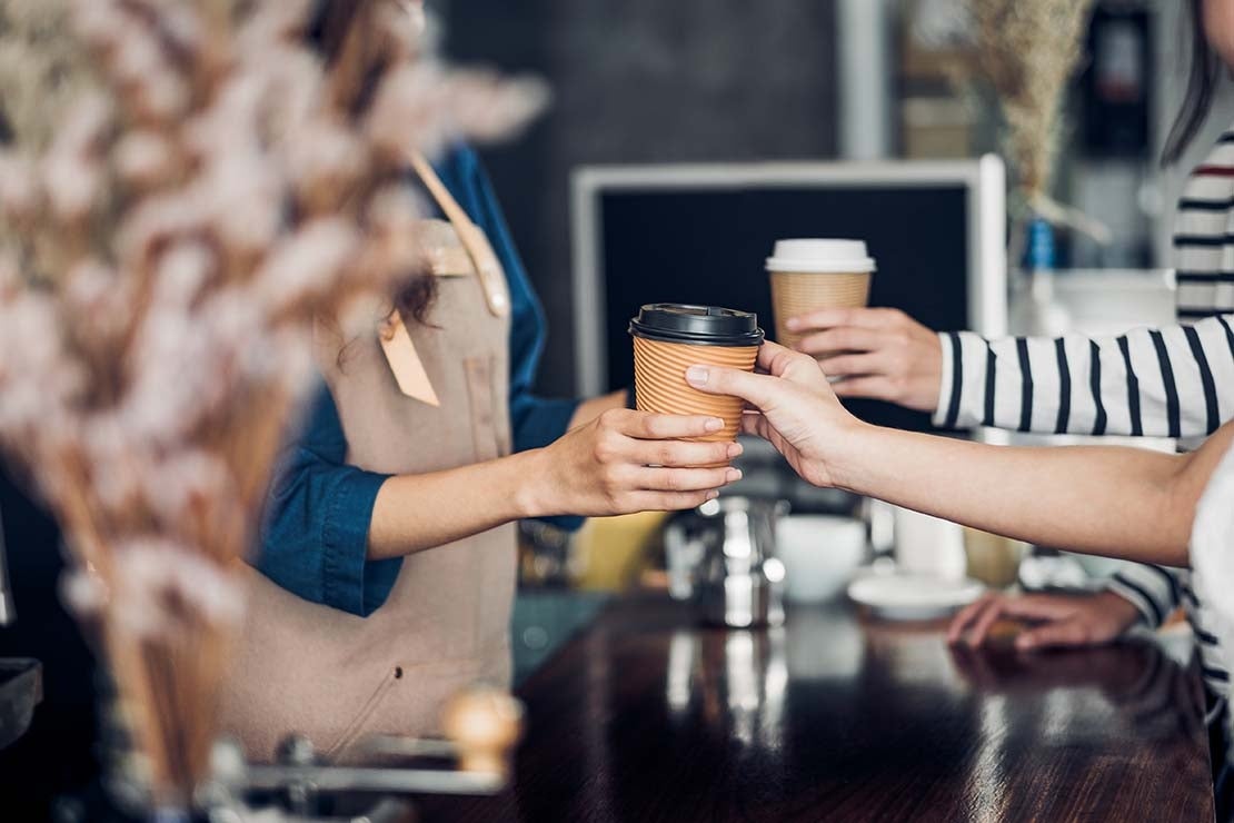 Cliente recibiendo un pedido en su cafetería favorita