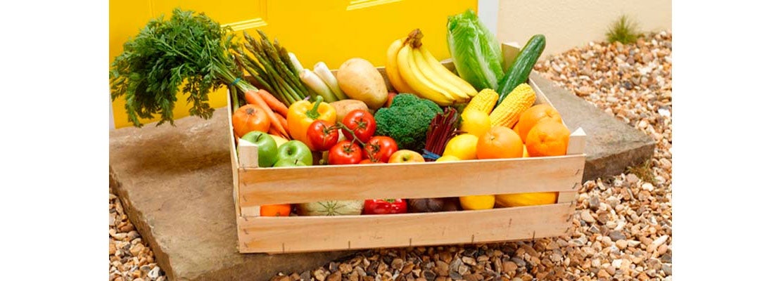 Productos de mercados locales empacados en una caja de madera