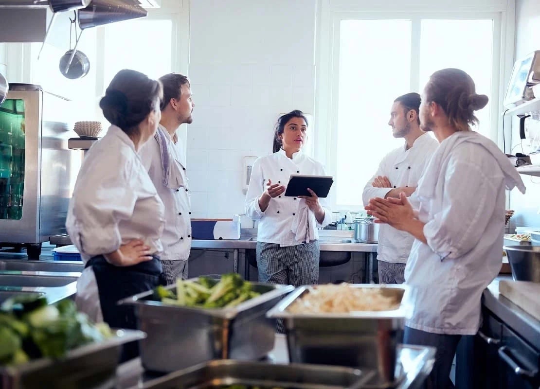 Equipo de chefs y ayudantes de cocina en una capacitación de personal