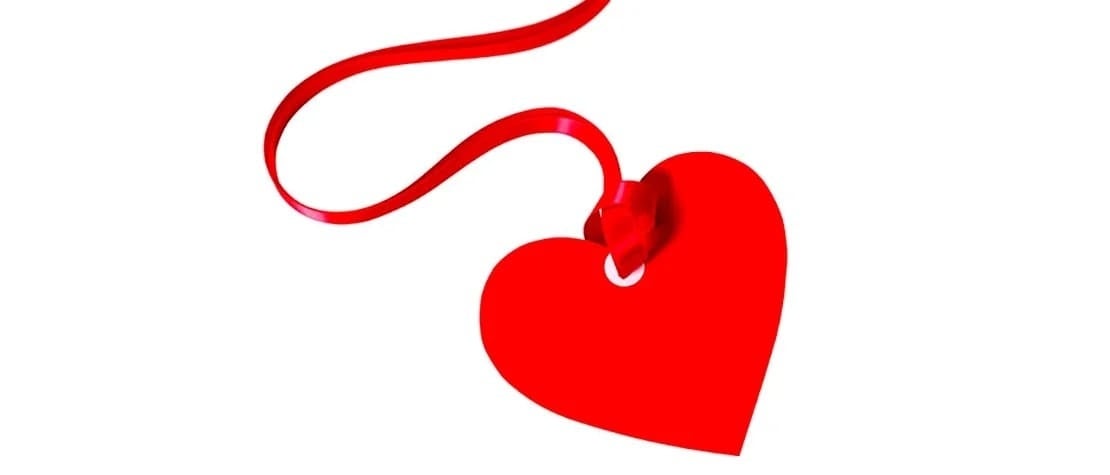 Corazón hecho en papel y con listón para decorar una cena romántica