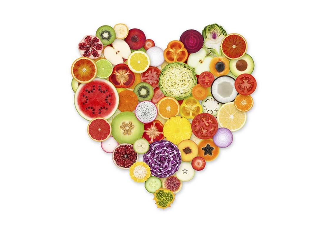 Collage en forma de corazón con rodajas de frutas y verduras