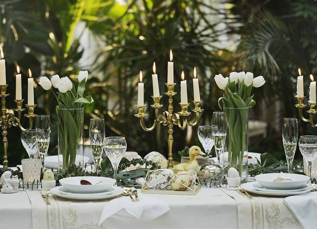 Velas, cubiertos y flores en un comedor de un restaurante temático que transmite frescura y conecta con la naturaleza