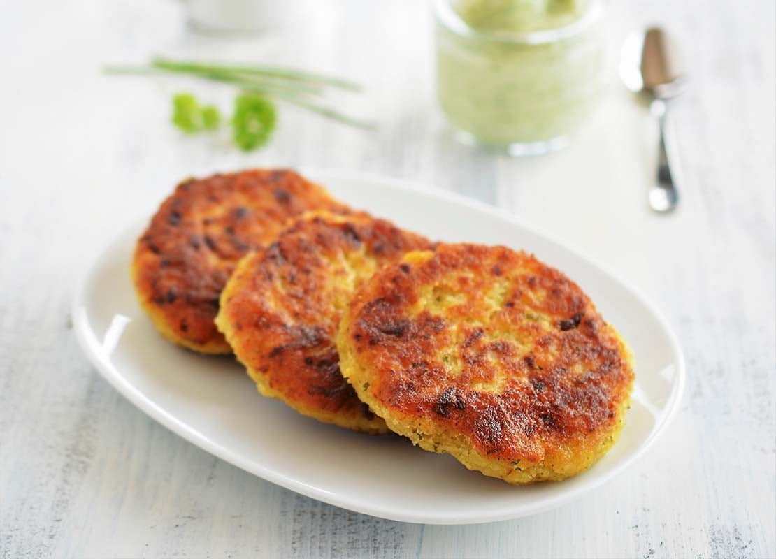 Sobre un plato blanco, 3 rodajas de proteína vegetal para hamburguesa elaboradas con garbanzo  