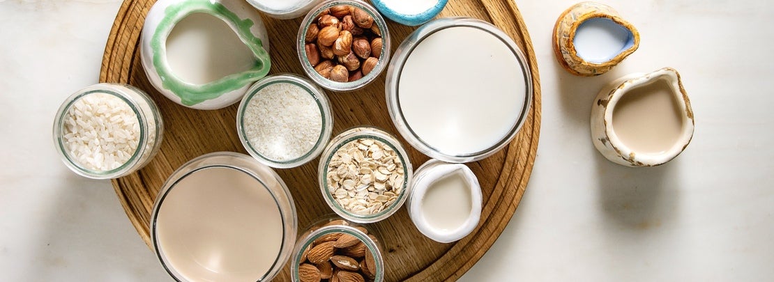 Bebidas vegetales de coco, avena, avellanas, almendras y arroz y recipientes con estos ingredientes
