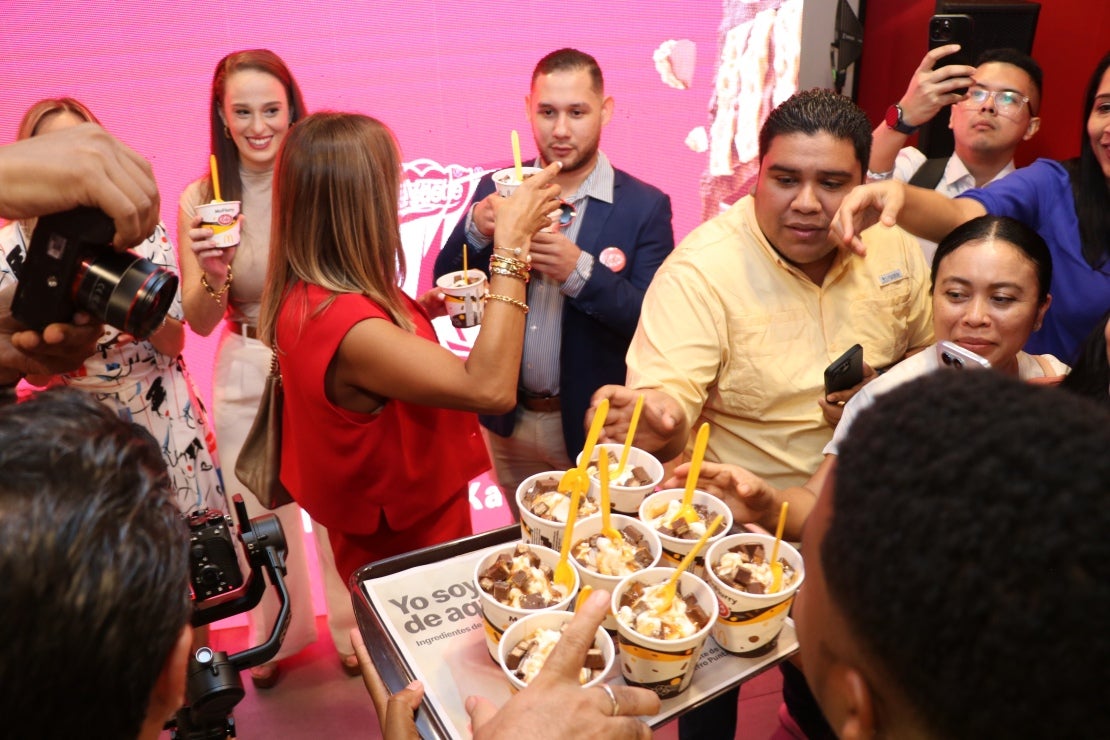 Personas en evento de celebración, recibiendo vasos de helado para degustar el nuevo McFlurry KitKat de McDonald's y NESTLÉ®