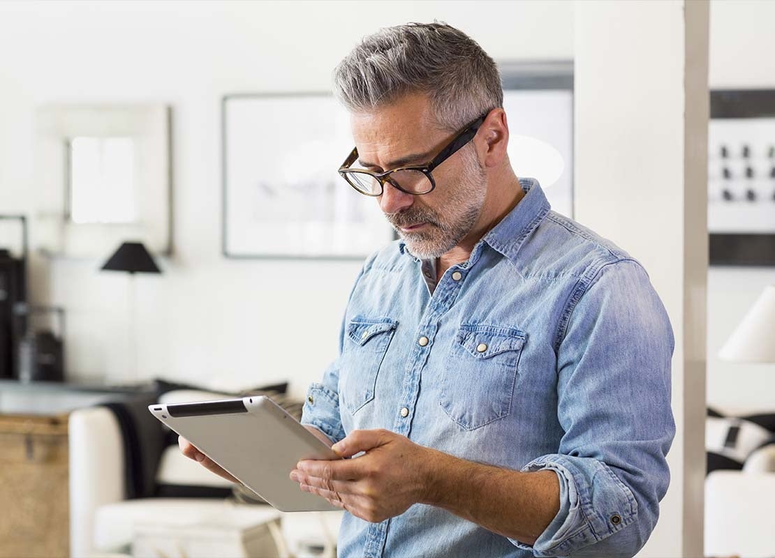 Emprendedor en su oficina revisa el presupuesto en una tablet para poner una cafetería