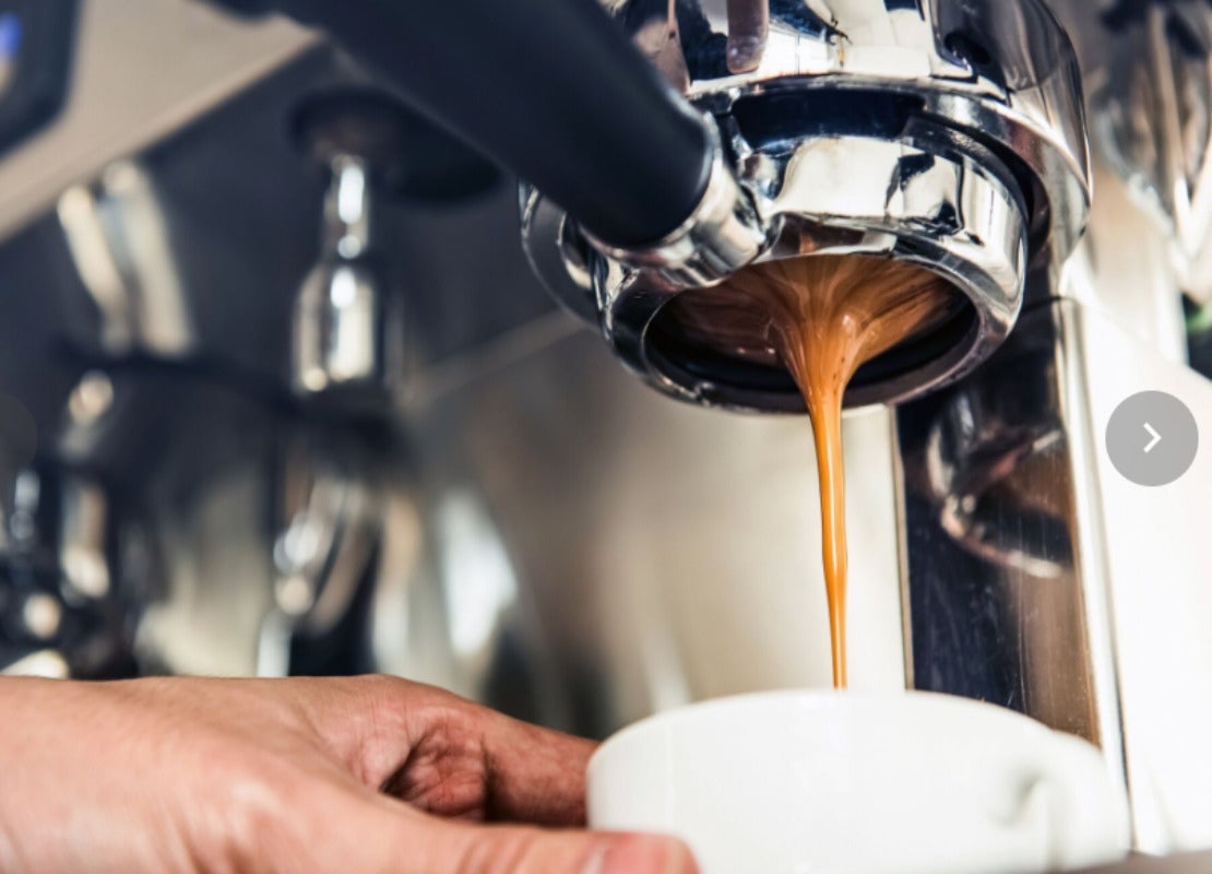 Preparación del café por máquina que fluye a través del portafiltros hacia una taza